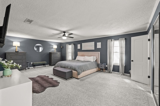 bedroom with light carpet, a textured ceiling, and ceiling fan