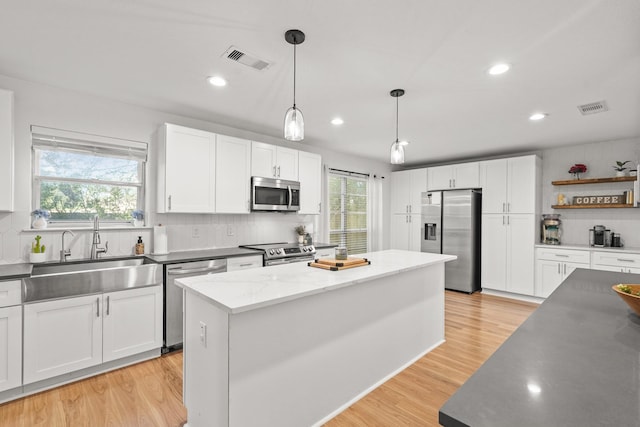 kitchen featuring white cabinetry, a kitchen island, and stainless steel appliances