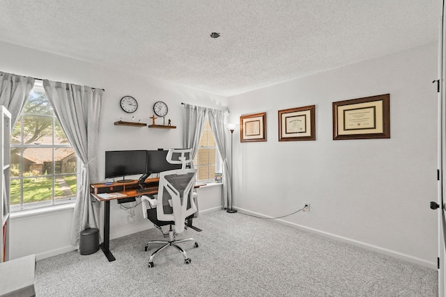 carpeted office featuring a textured ceiling