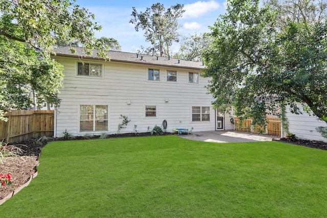 rear view of house featuring a lawn and a patio area