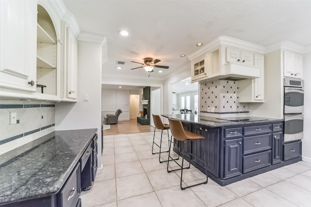 kitchen featuring white cabinetry, ceiling fan, black electric cooktop, and blue cabinetry