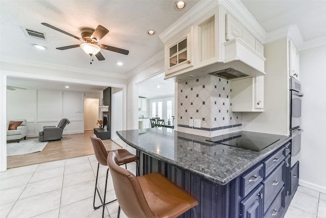 kitchen with white cabinetry, blue cabinets, light tile patterned flooring, and black electric cooktop