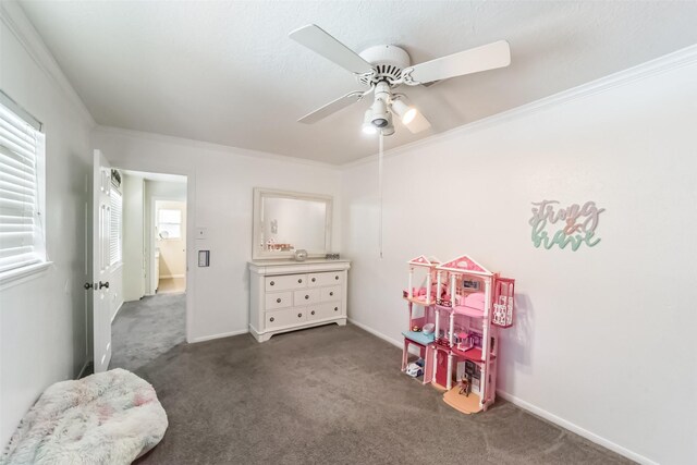 playroom featuring ceiling fan, ornamental molding, and dark carpet