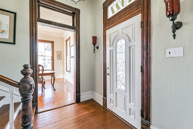 entrance foyer featuring wood-type flooring and ornamental molding