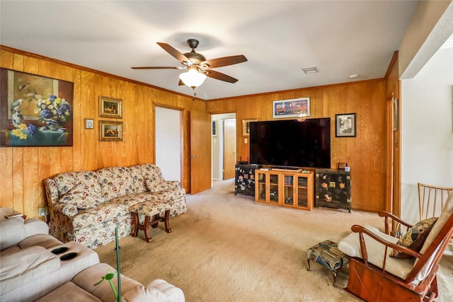 carpeted living room featuring ceiling fan and ornamental molding