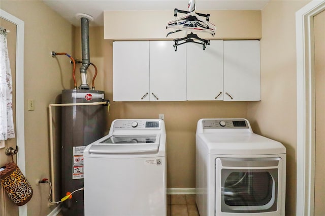 clothes washing area with cabinets, washer and clothes dryer, water heater, and tile patterned flooring