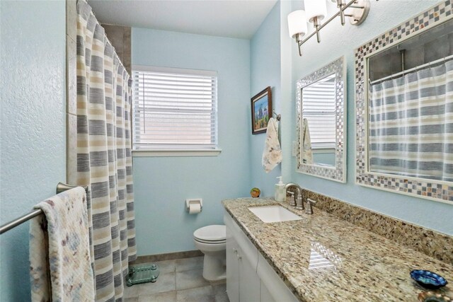 bathroom with tile patterned floors, toilet, an inviting chandelier, baseboards, and vanity