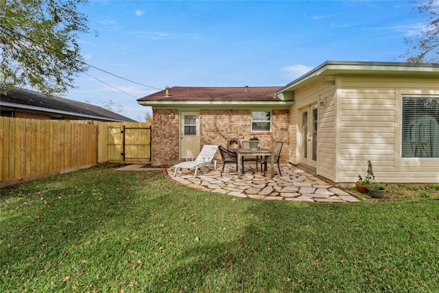 rear view of property with a lawn and a patio area