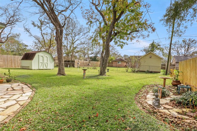 view of yard with a storage shed, a fenced backyard, and an outdoor structure