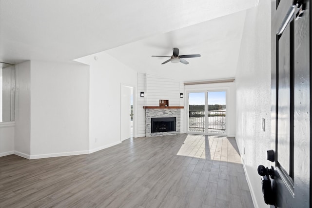 unfurnished living room featuring hardwood / wood-style flooring, ceiling fan, a fireplace, and vaulted ceiling