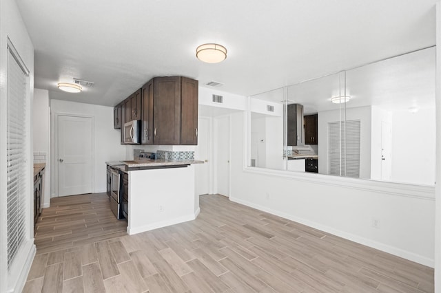 kitchen featuring dark brown cabinets, light wood-type flooring, and stainless steel appliances