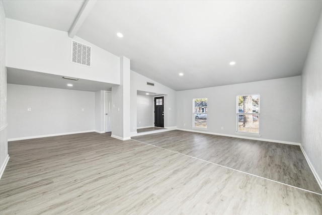 unfurnished living room featuring light hardwood / wood-style floors, beam ceiling, and high vaulted ceiling