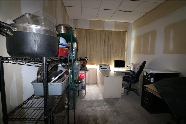 office featuring unfinished concrete floors and a drop ceiling