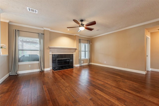 unfurnished living room with a tiled fireplace, crown molding, dark hardwood / wood-style flooring, and a textured ceiling