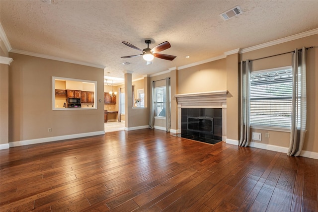 unfurnished living room featuring crown molding, ceiling fan with notable chandelier, a tile fireplace, and dark hardwood / wood-style floors