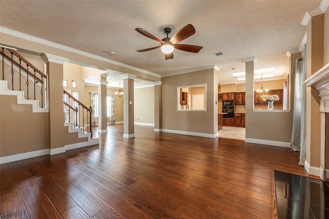 unfurnished living room featuring wood-type flooring, ceiling fan with notable chandelier, a textured ceiling, and ornate columns