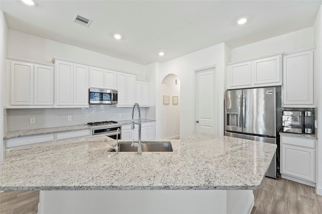 kitchen featuring white cabinetry, sink, a kitchen island with sink, and appliances with stainless steel finishes