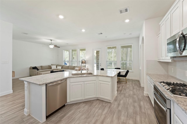 kitchen with sink, white cabinets, a center island with sink, and appliances with stainless steel finishes