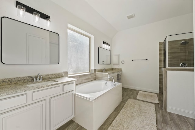 bathroom featuring vanity, plus walk in shower, and lofted ceiling