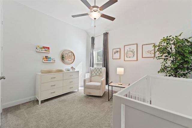 bedroom featuring ceiling fan, lofted ceiling, light carpet, and a nursery area