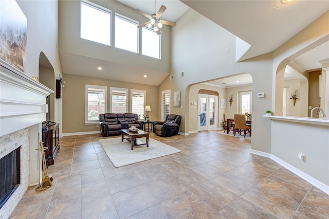 living room featuring ceiling fan, sink, and a towering ceiling