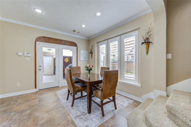 tiled dining room featuring ornamental molding