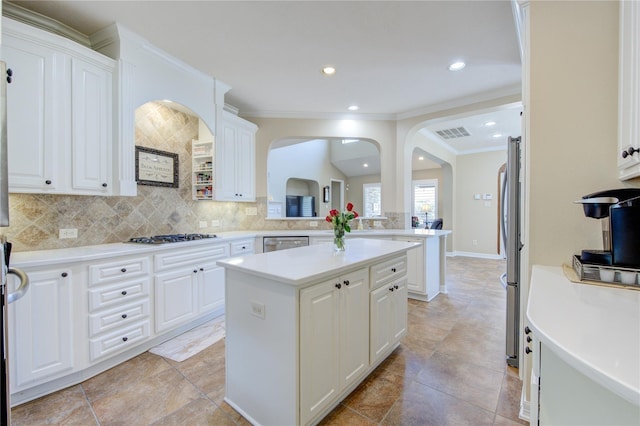 kitchen featuring a center island, white cabinetry, appliances with stainless steel finishes, and tasteful backsplash