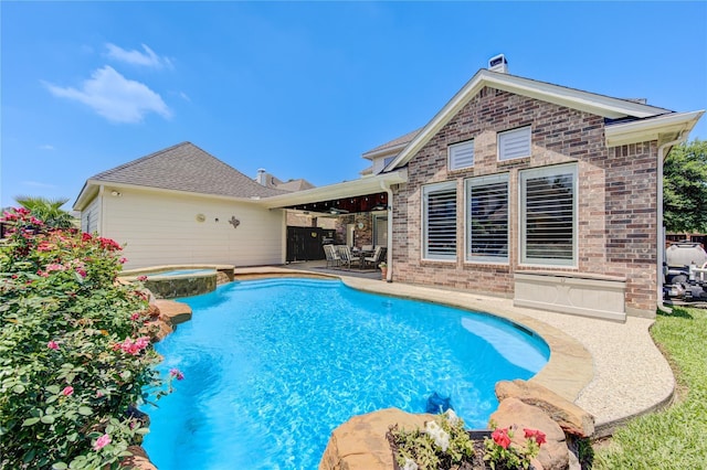 view of swimming pool with an in ground hot tub and a patio area