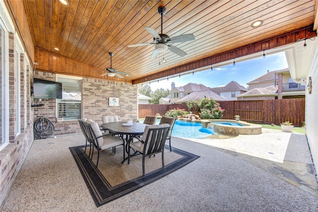 view of patio with ceiling fan and a swimming pool with hot tub