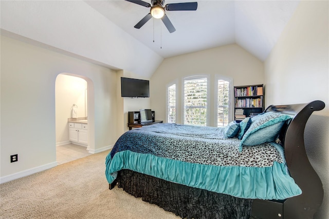 bedroom featuring connected bathroom, light colored carpet, ceiling fan, and lofted ceiling