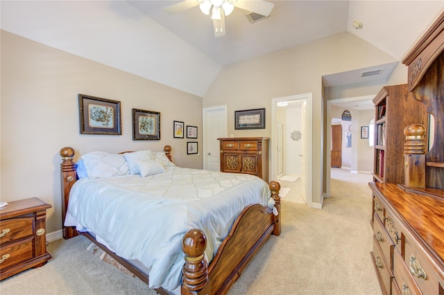 bedroom with ceiling fan, light colored carpet, lofted ceiling, and ensuite bath