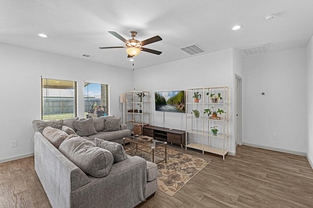 living room featuring ceiling fan and dark wood-type flooring