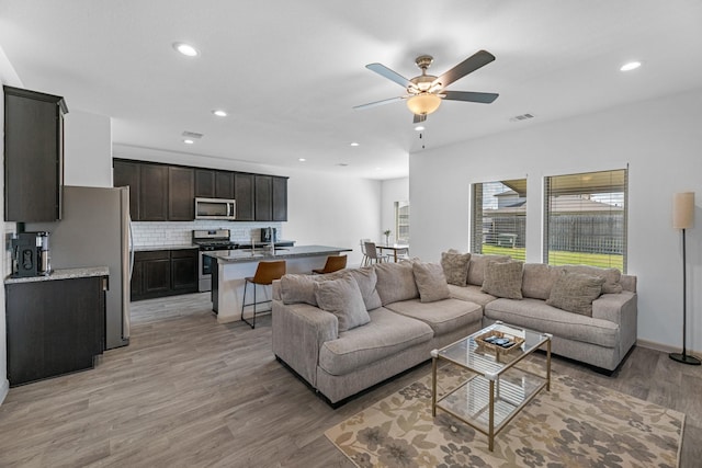 living room featuring light wood-type flooring and ceiling fan