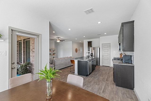 dining area featuring light hardwood / wood-style floors, ceiling fan, and sink