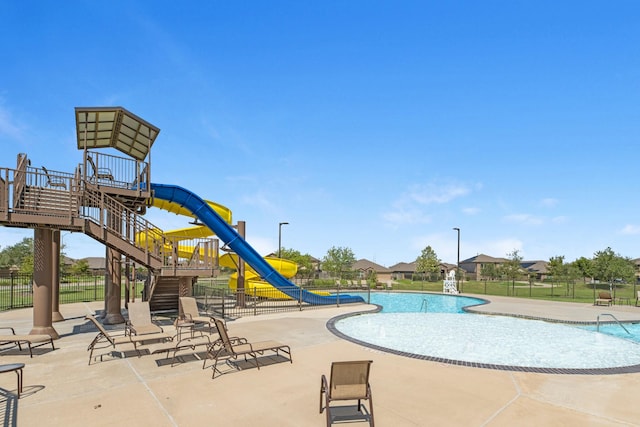 view of pool featuring a water slide and a patio