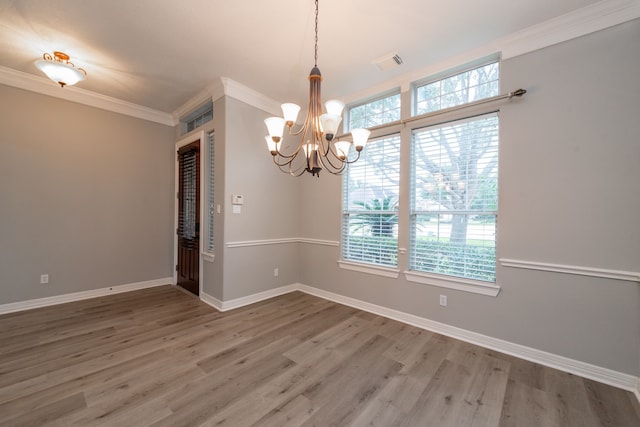 unfurnished room featuring a chandelier, hardwood / wood-style floors, and ornamental molding