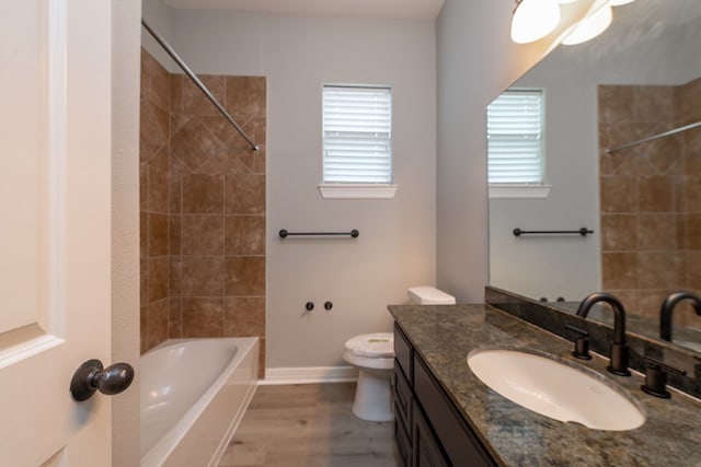 full bathroom with toilet, tiled shower / bath combo, vanity, and hardwood / wood-style floors