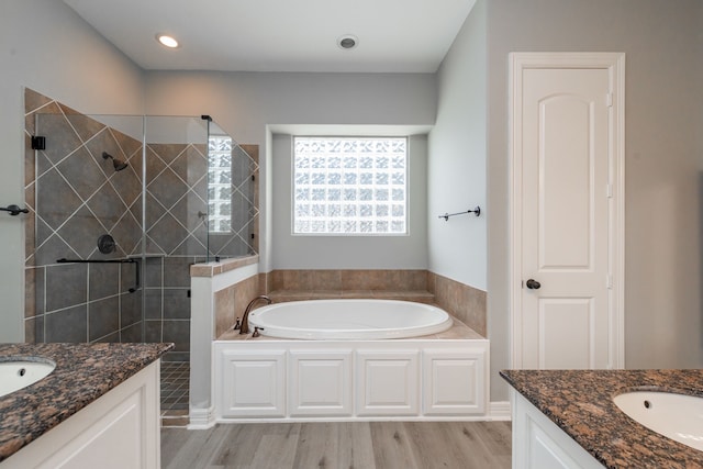 bathroom featuring shower with separate bathtub, vanity, and wood-type flooring