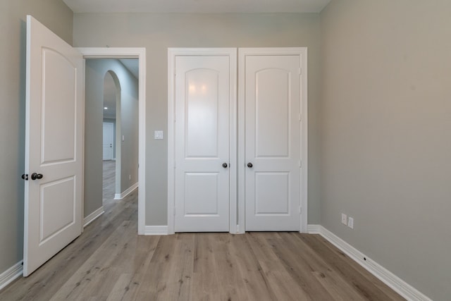 unfurnished bedroom with light hardwood / wood-style floors and a closet