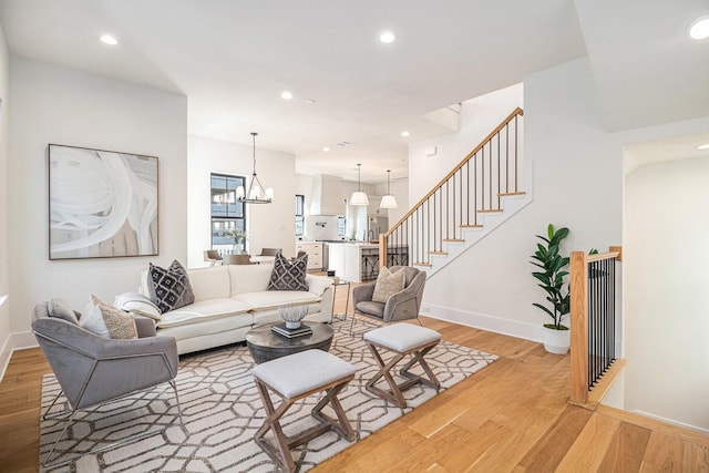 living room with light hardwood / wood-style floors and a notable chandelier