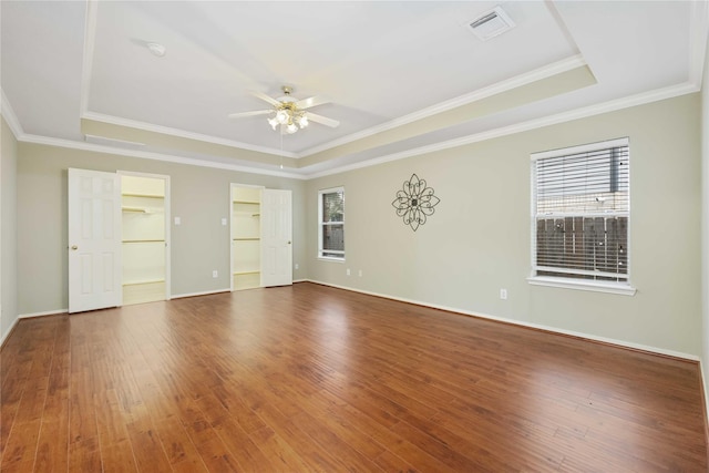 spare room with hardwood / wood-style flooring, ornamental molding, and a raised ceiling