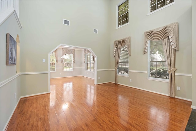 unfurnished living room with a high ceiling and hardwood / wood-style floors