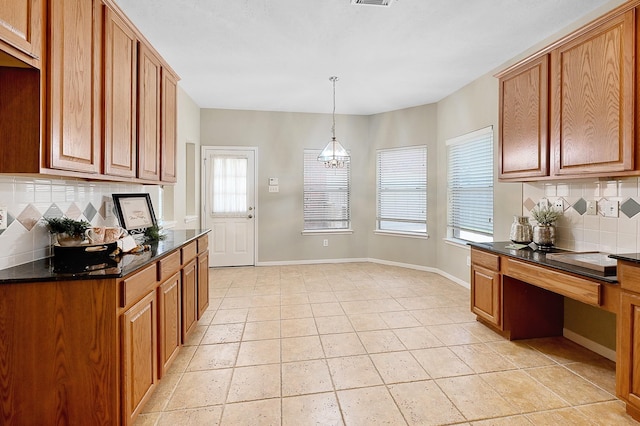 kitchen with hanging light fixtures, a healthy amount of sunlight, and backsplash