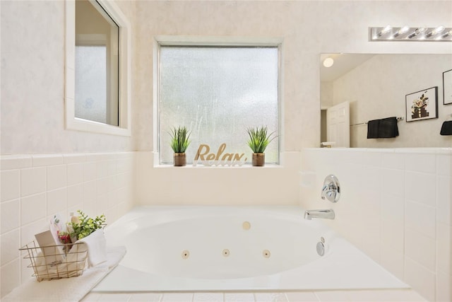 bathroom featuring tiled bath and a wealth of natural light