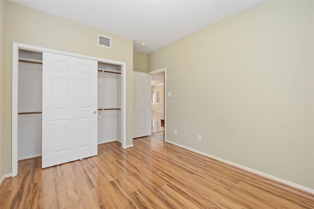 unfurnished bedroom featuring light hardwood / wood-style flooring and a closet