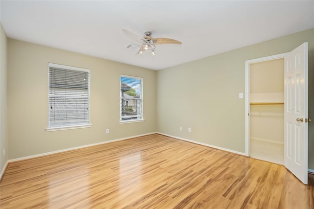 spare room with light wood-type flooring and ceiling fan