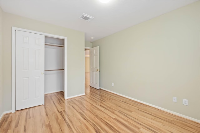 unfurnished bedroom featuring a closet and light hardwood / wood-style floors