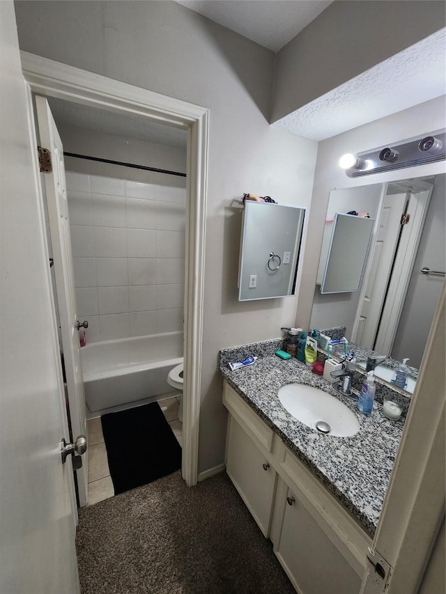 full bathroom with tile patterned flooring, vanity, toilet, and tiled shower / bath