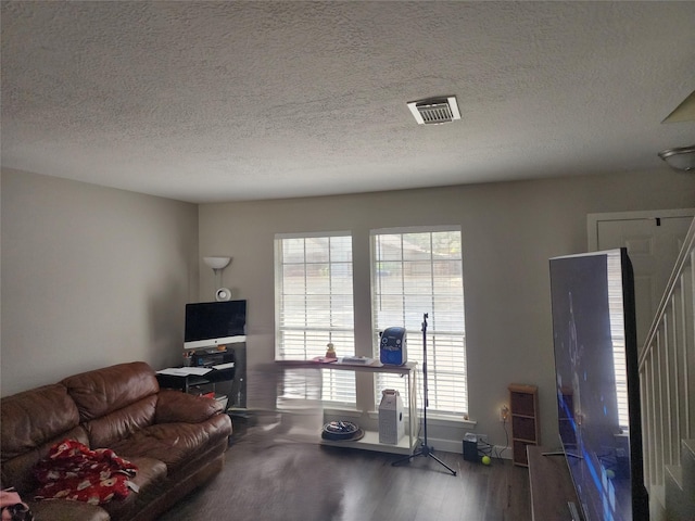 living room with a textured ceiling and hardwood / wood-style flooring