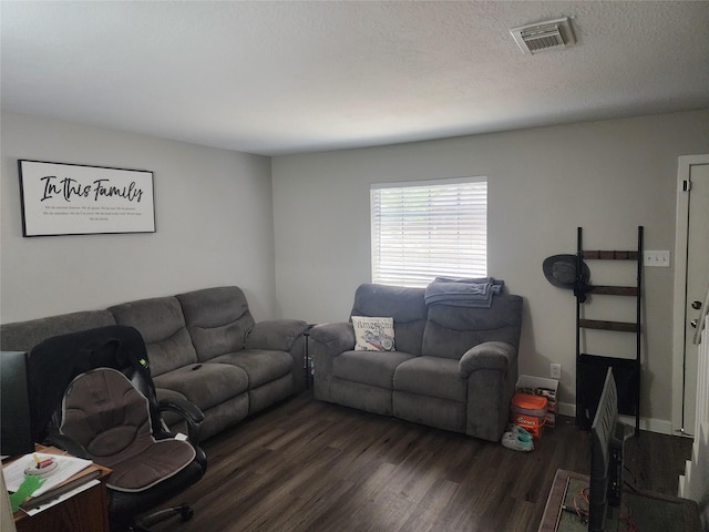 living room featuring dark hardwood / wood-style floors and a textured ceiling